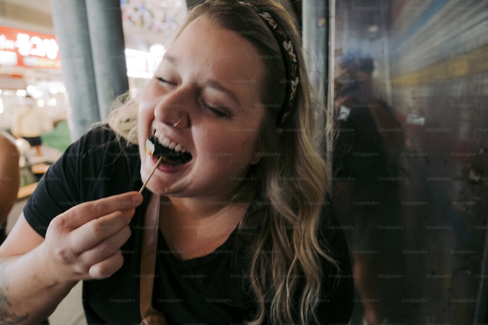 a woman eating food with a spoon in her mouth