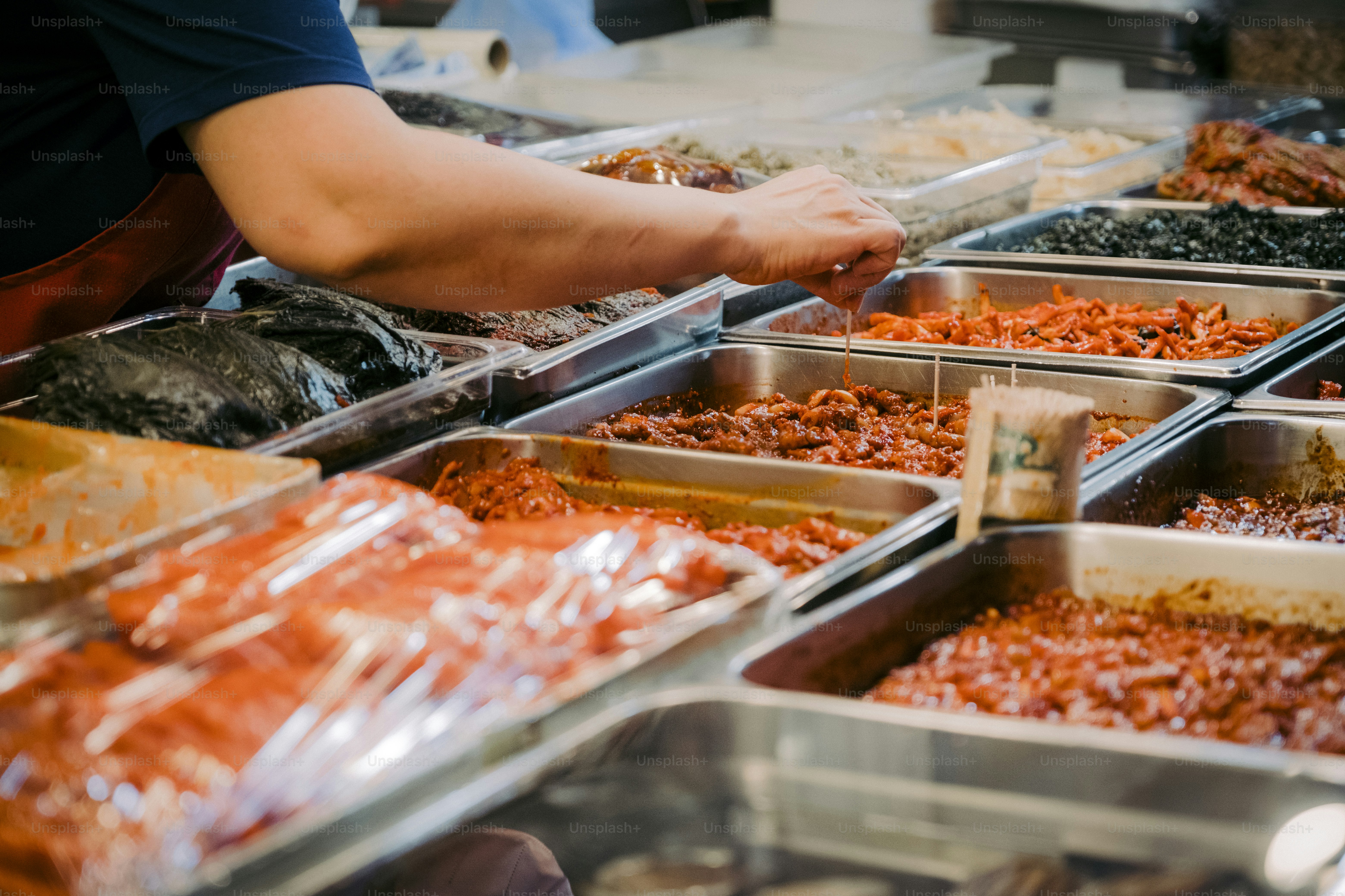 a person reaching for food at a buffet