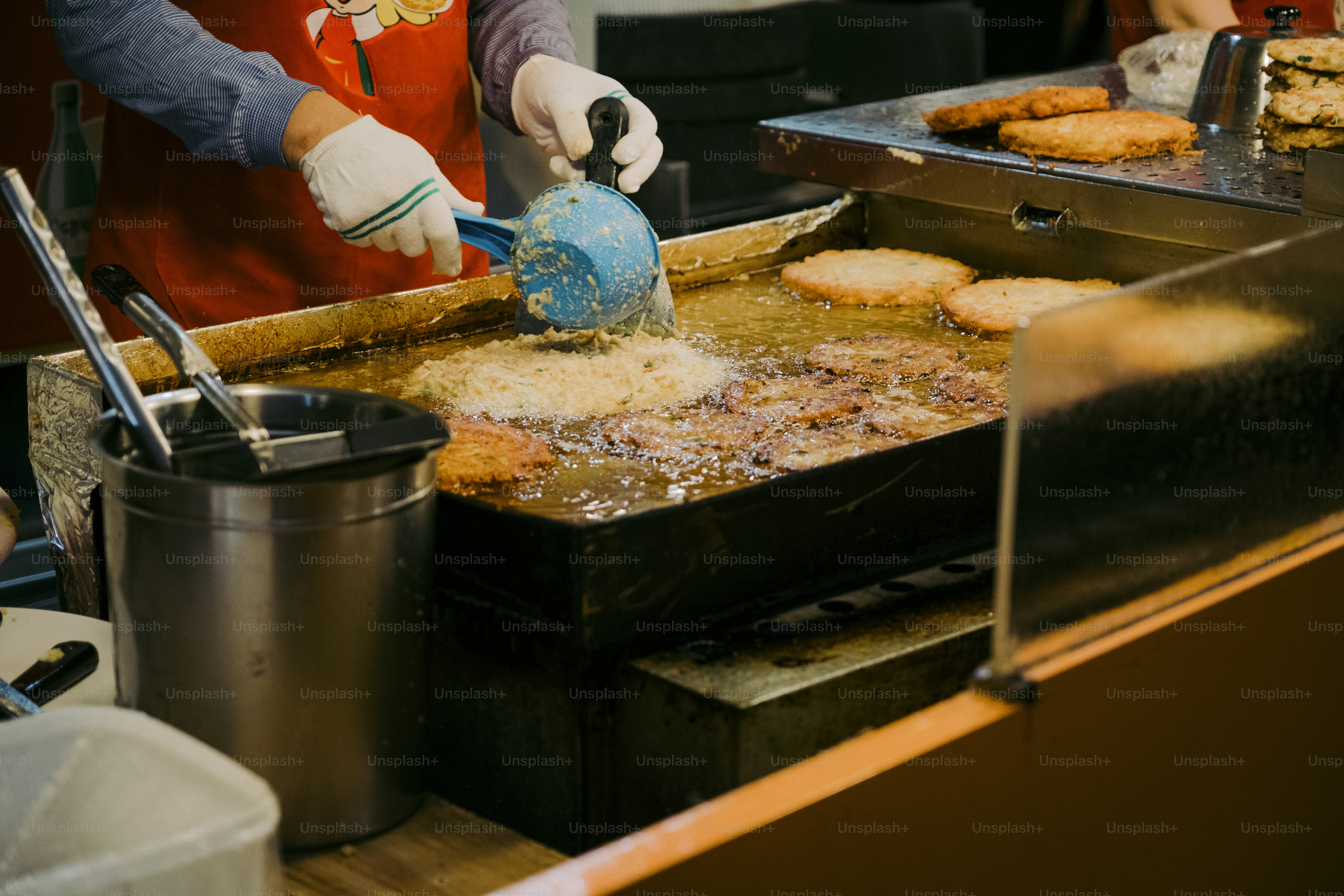 a person in a red shirt is making food on a grill