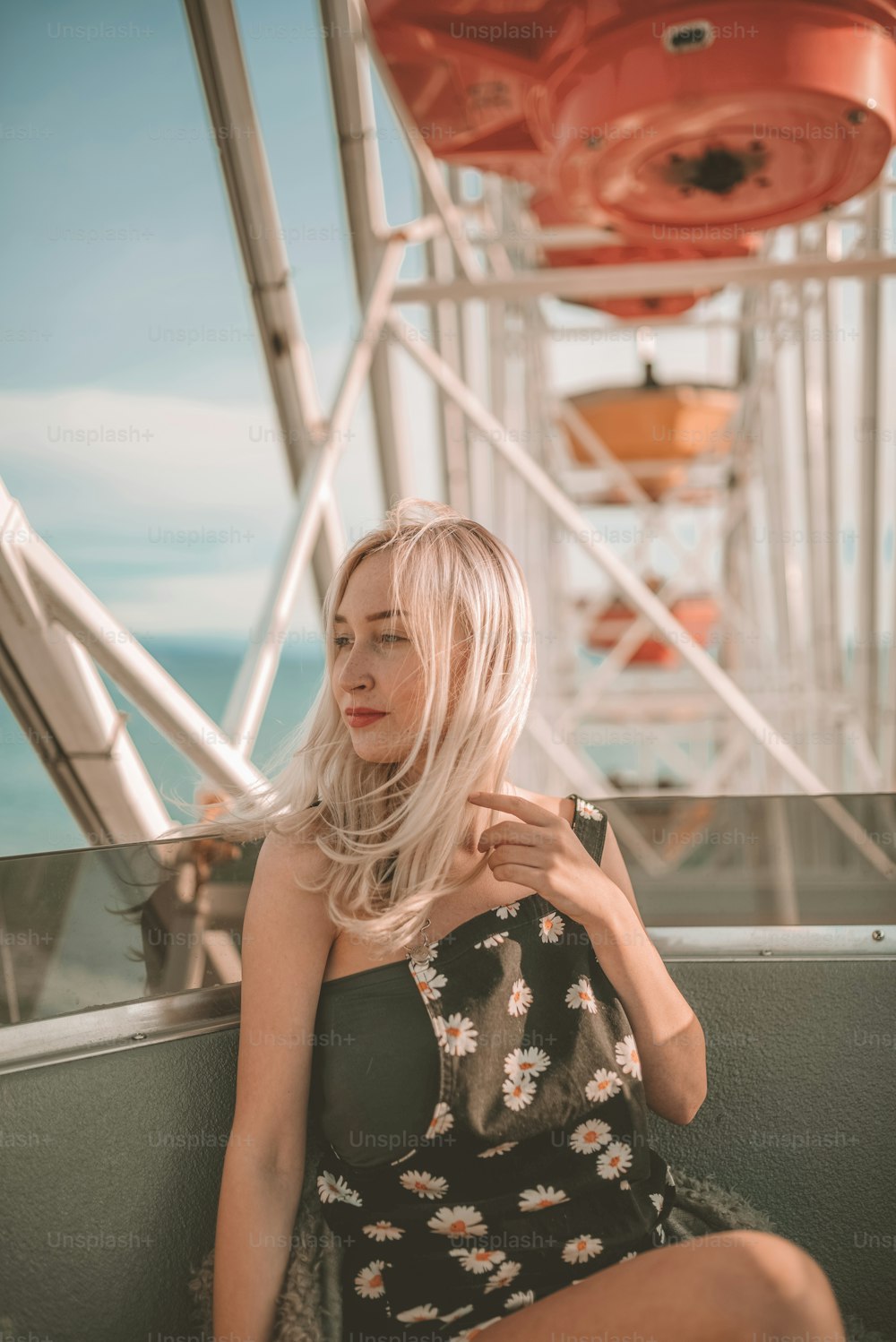 a woman sitting on a bench in front of a ferris wheel