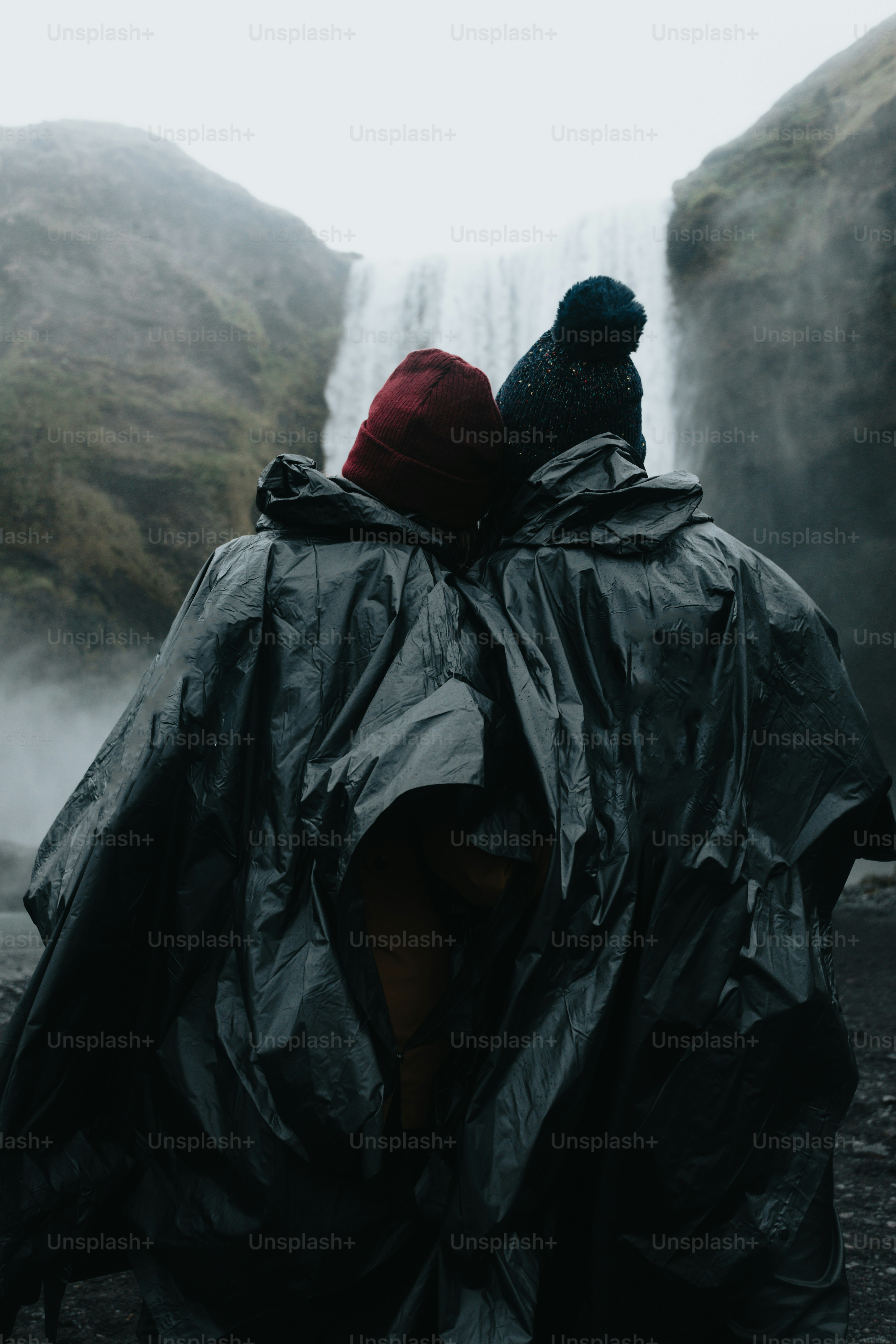 Beberapa orang berdiri di samping air terjun