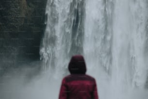eine Person, die vor einem Wasserfall steht