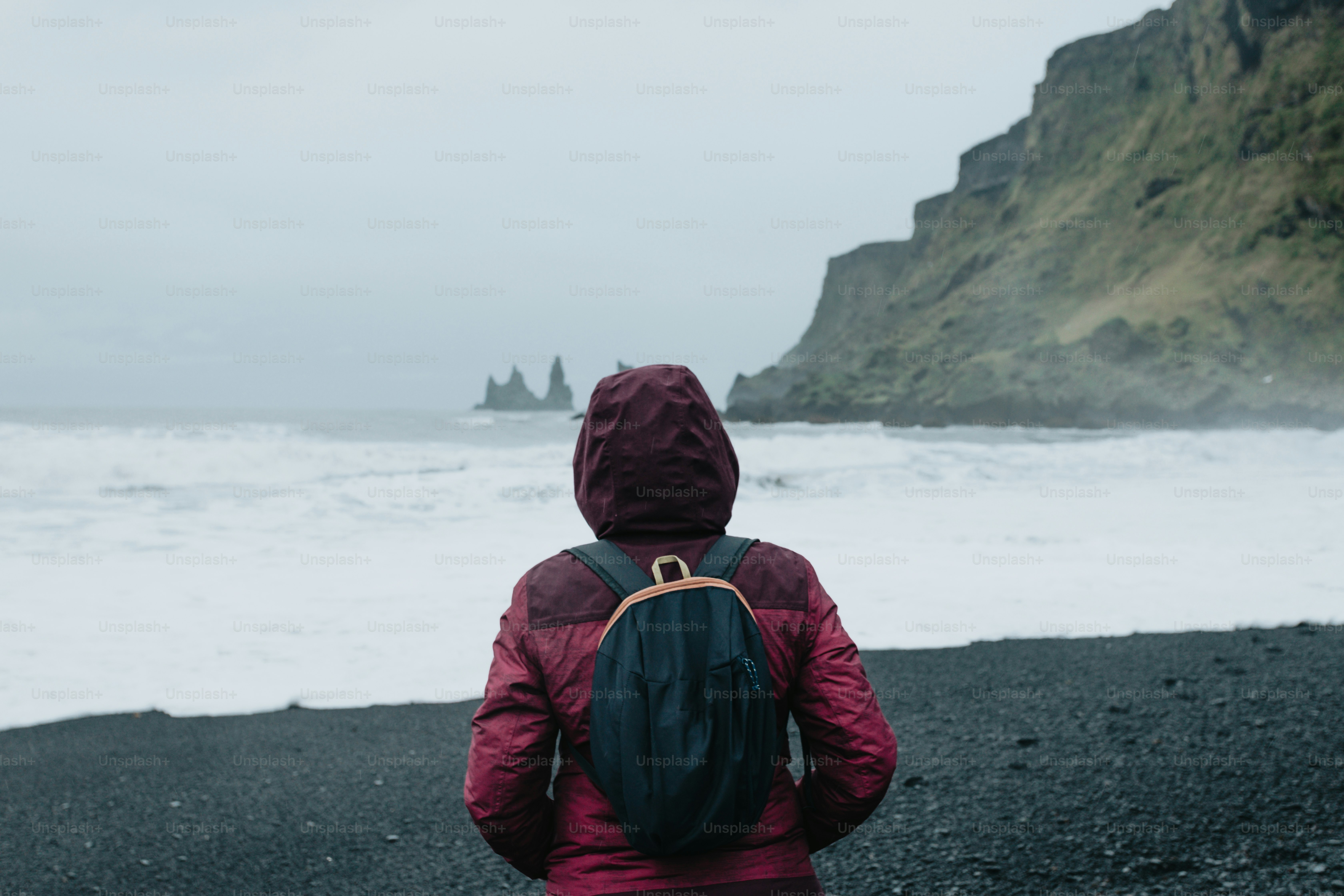 a person with a backpack standing on a beach