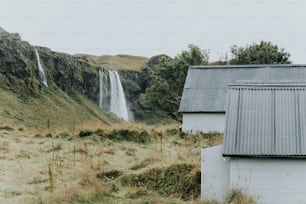 a house with a metal roof next to a waterfall