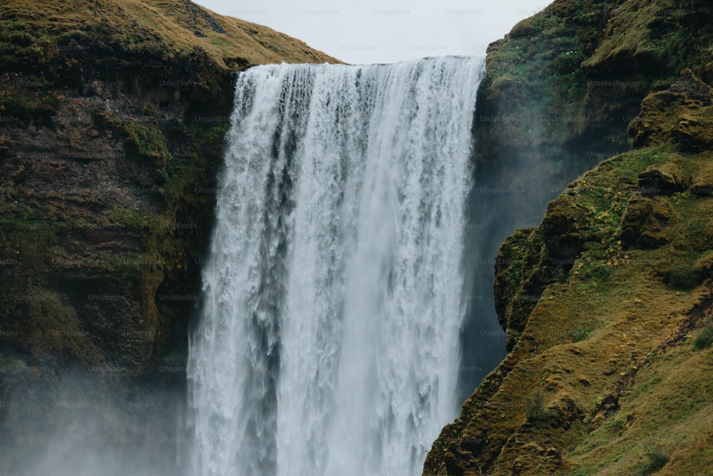 Una grande cascata con acqua che scende lungo i suoi lati