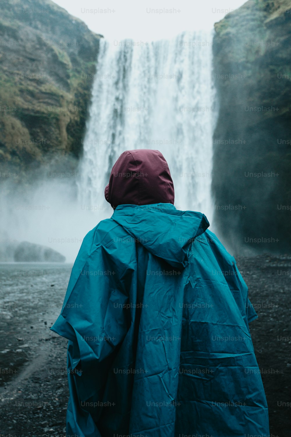 uma pessoa em pé na frente de uma cachoeira