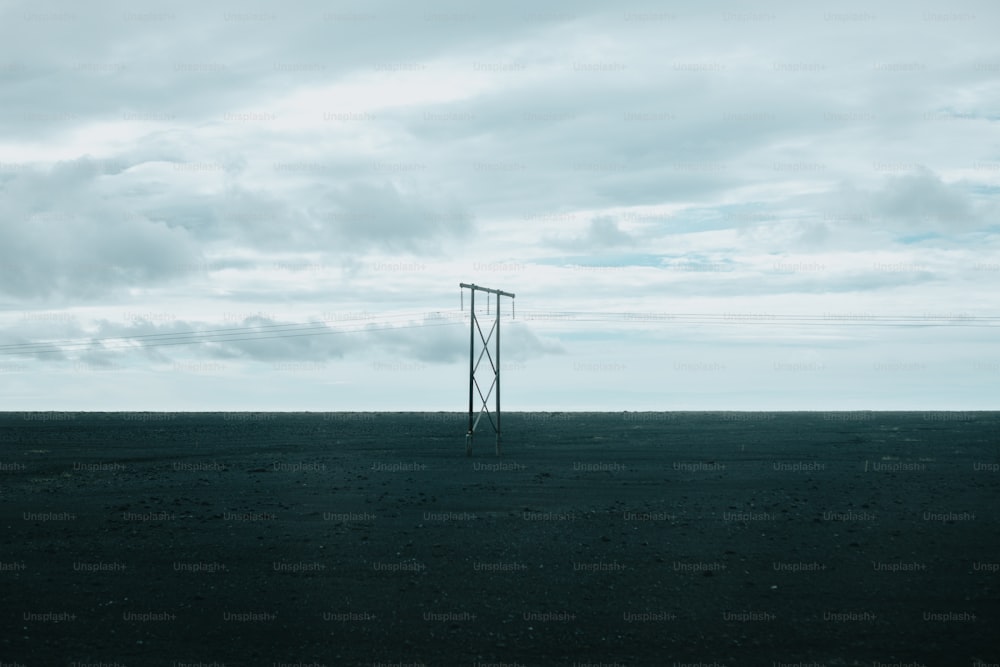 an empty field with a telephone pole in the distance