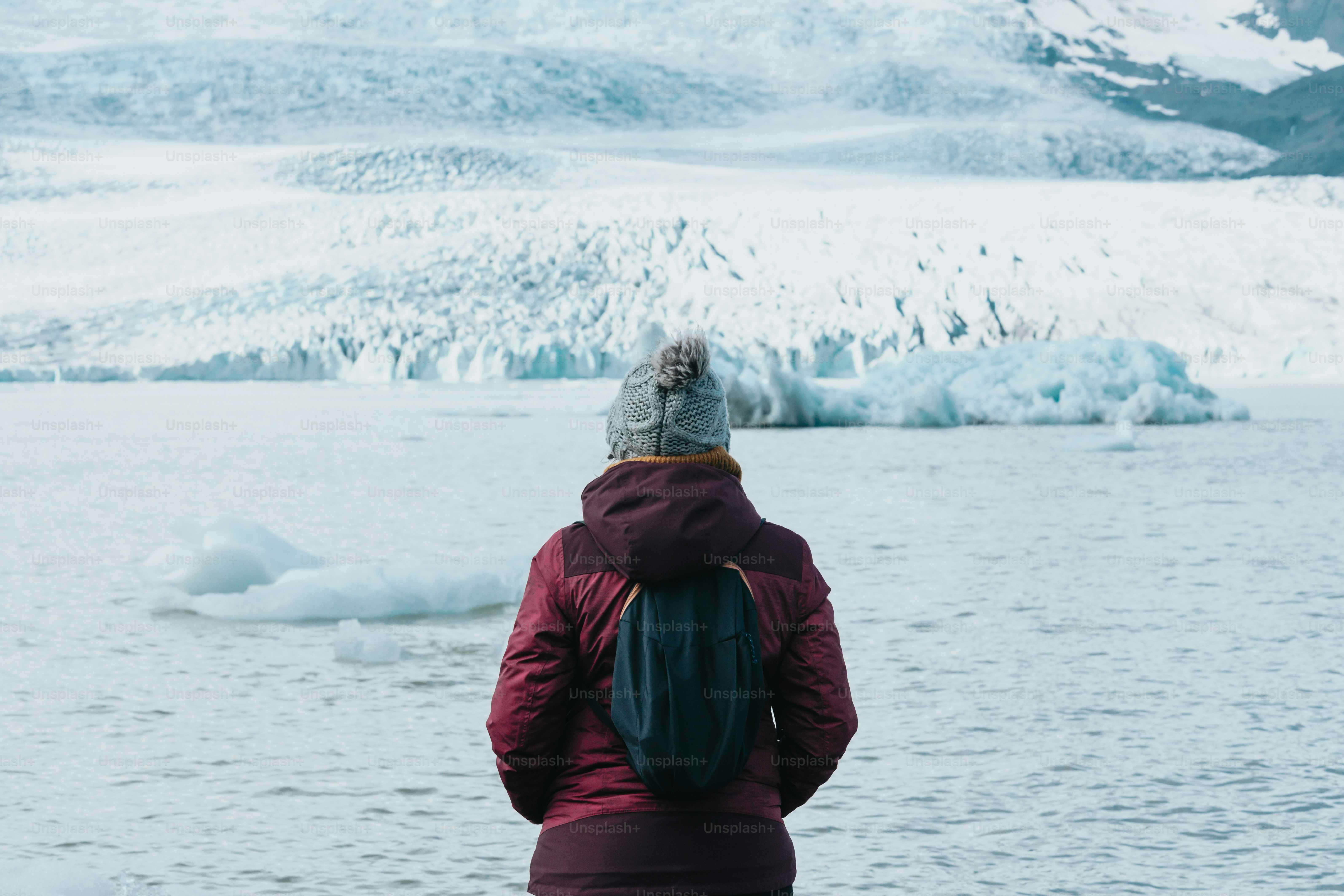 Foto Una persona parada frente a un cuerpo de agua – Glaciar Imagen en ...