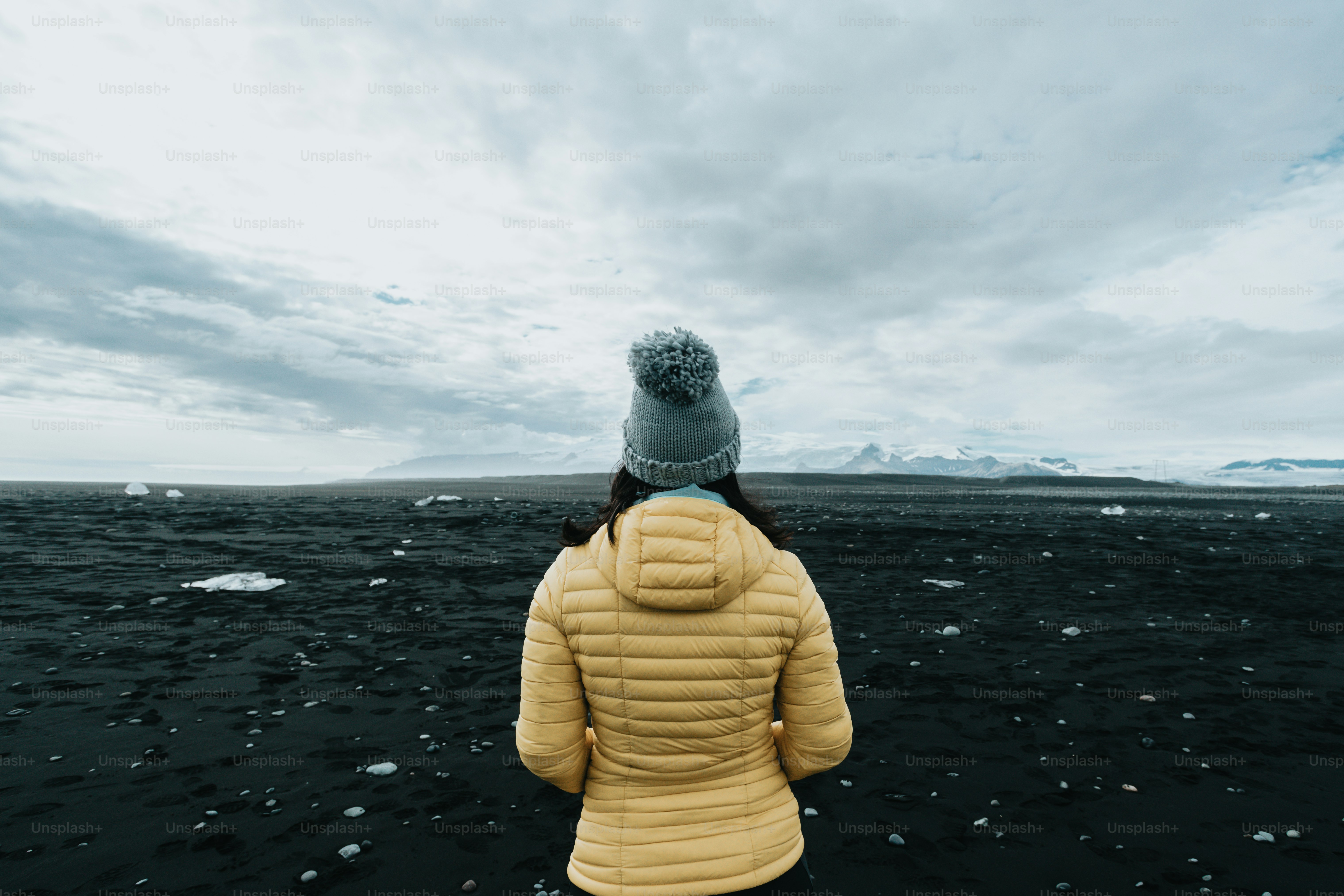 a woman in a yellow jacket is standing in the water