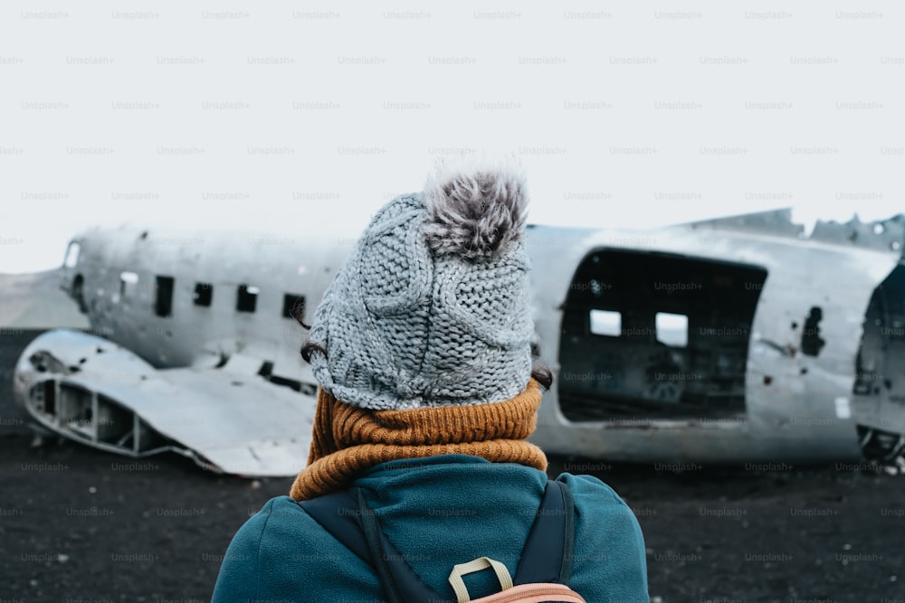 Una persona parada frente a un viejo avión