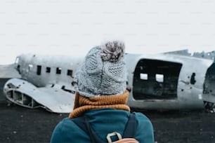 une personne debout devant un vieil avion