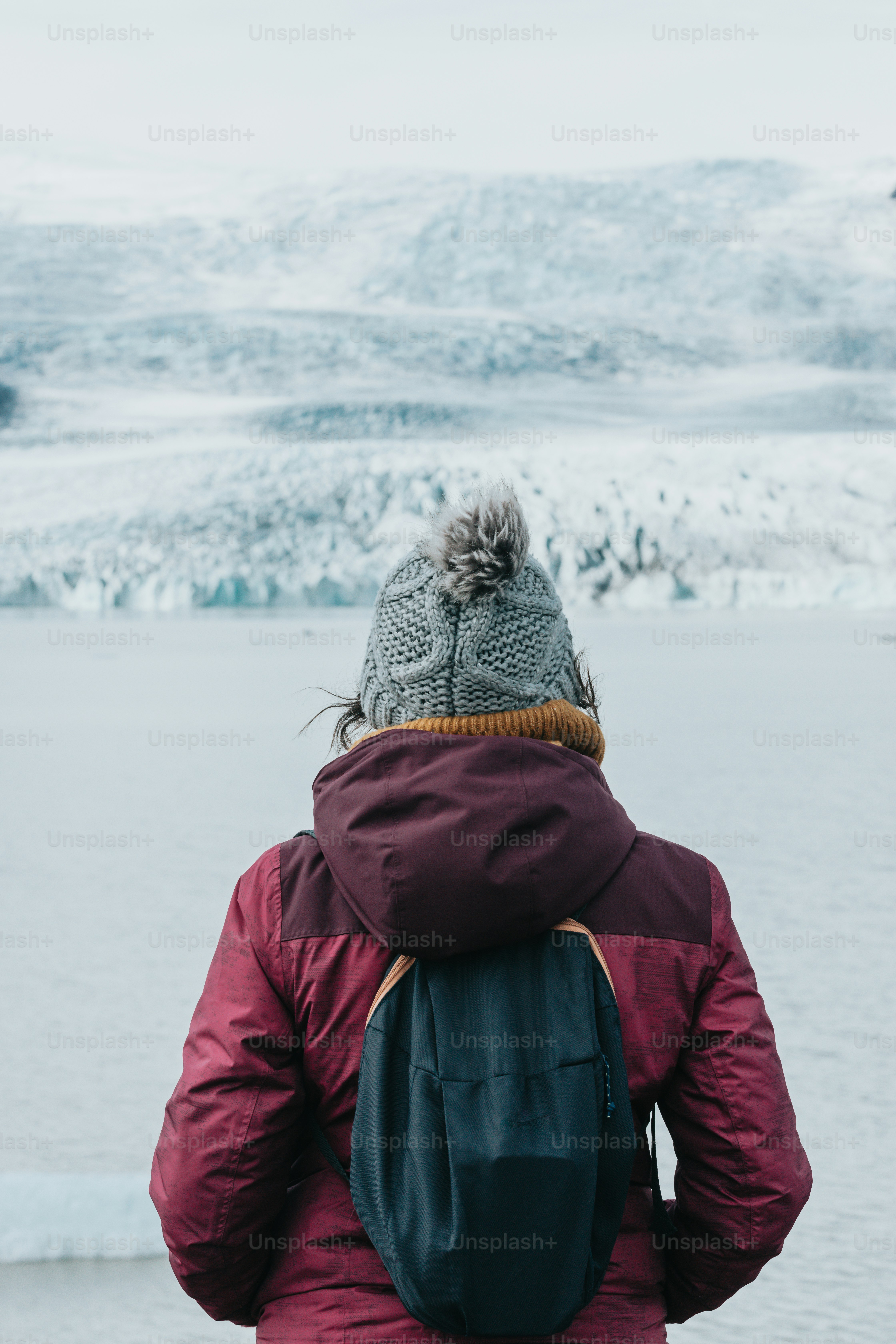 a person with a backpack standing in front of a body of water