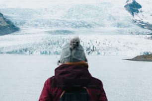 a person standing in front of a glacier