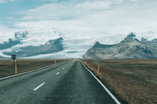 an empty road with mountains in the background