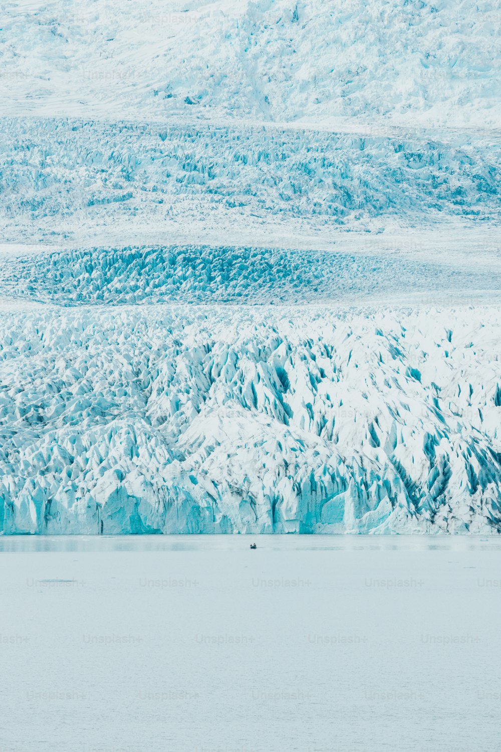 Un grupo de personas en un bote frente a un glaciar