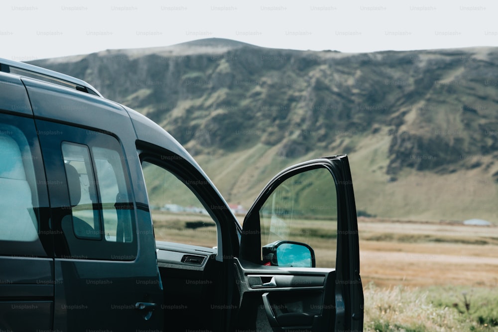 a truck is parked in a field with mountains in the background