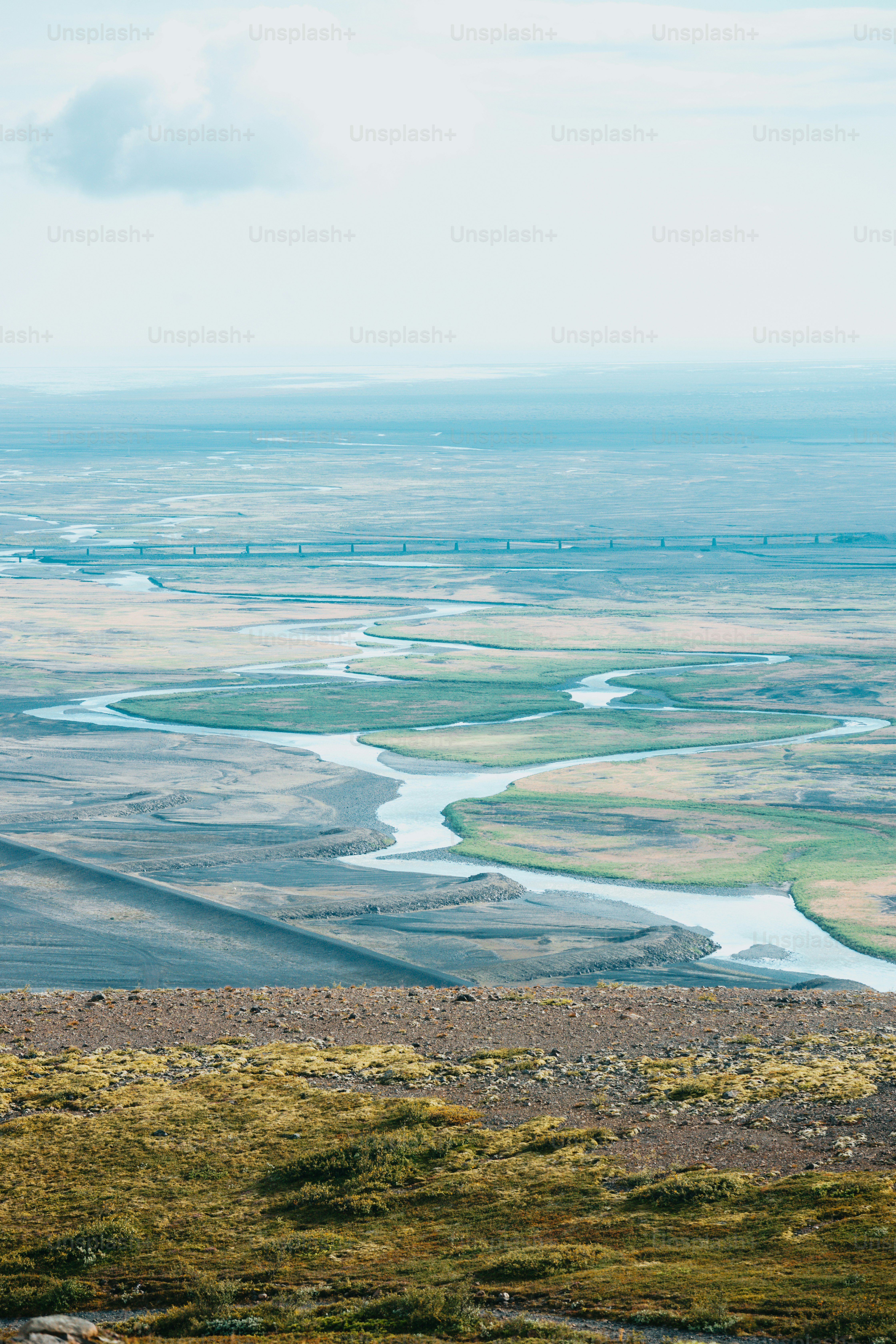 a man standing on top of a hill next to a river