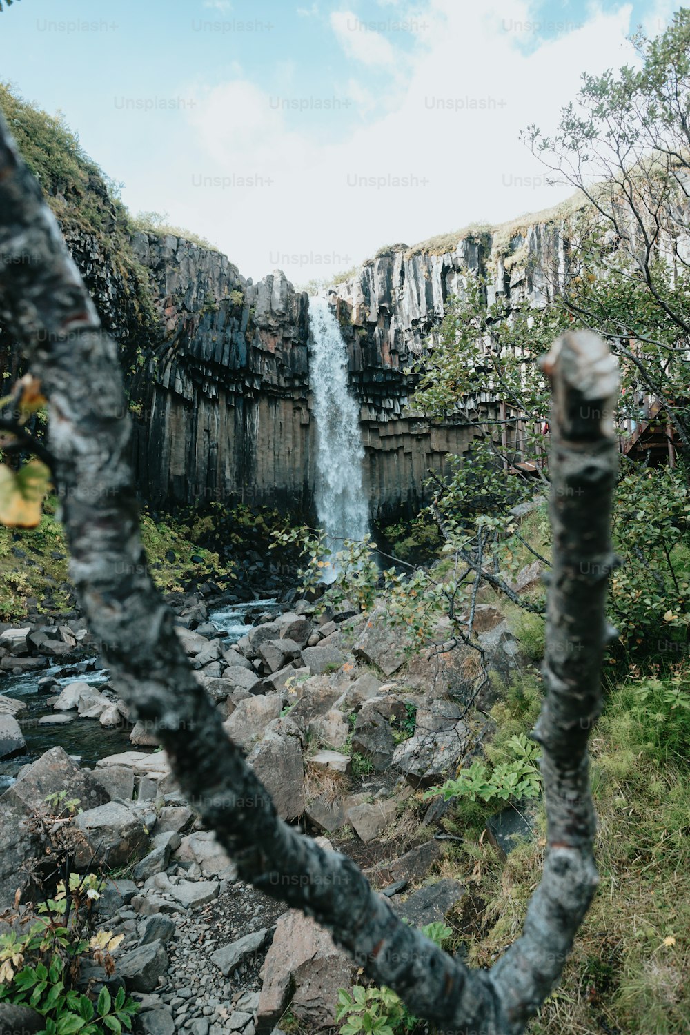 una vista di una cascata da dietro alcune rocce