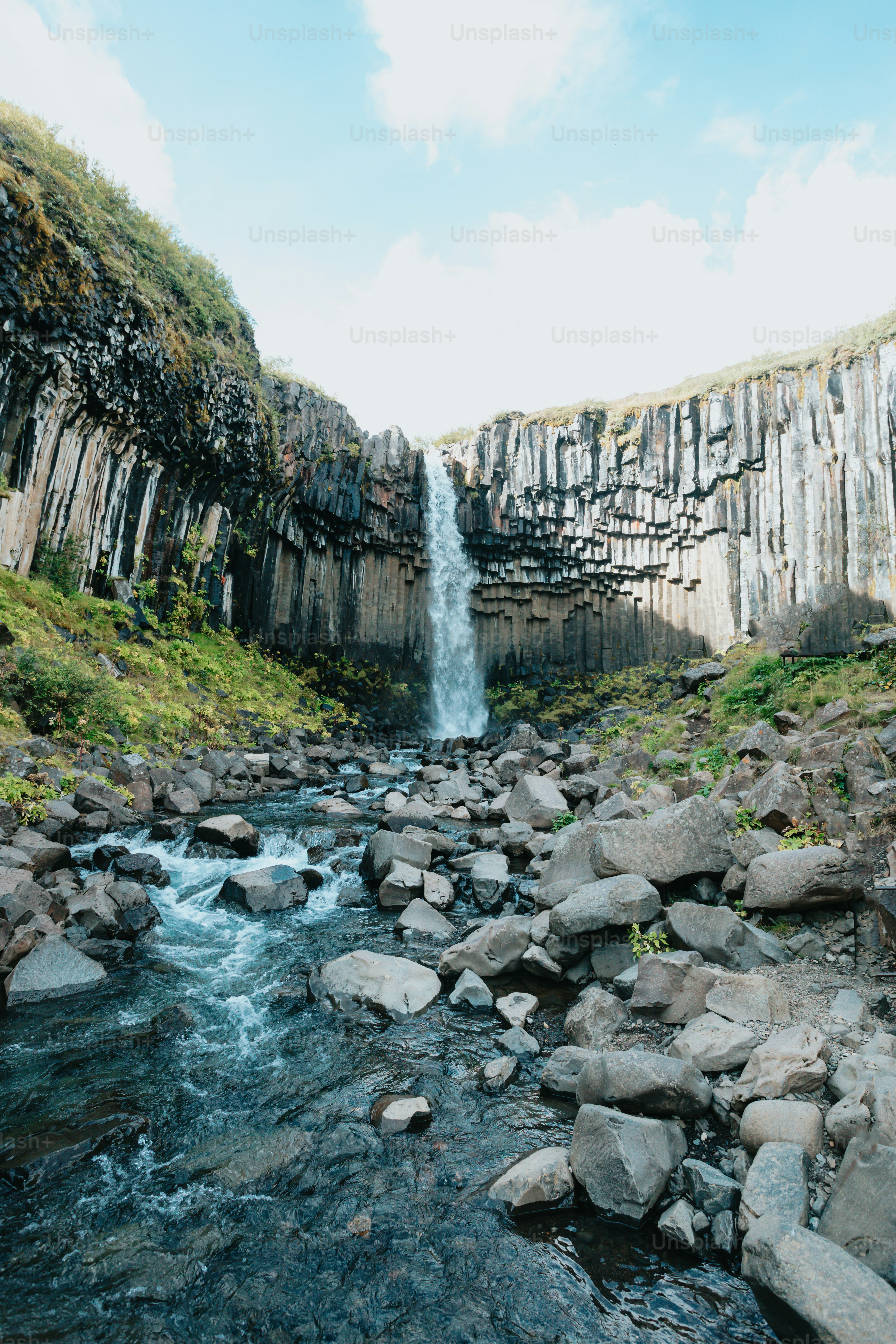 a small waterfall in the middle of a rocky river