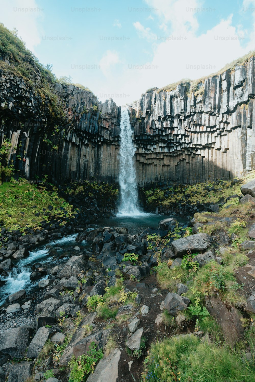 Una cascata sta uscendo dalle rocce nell'acqua