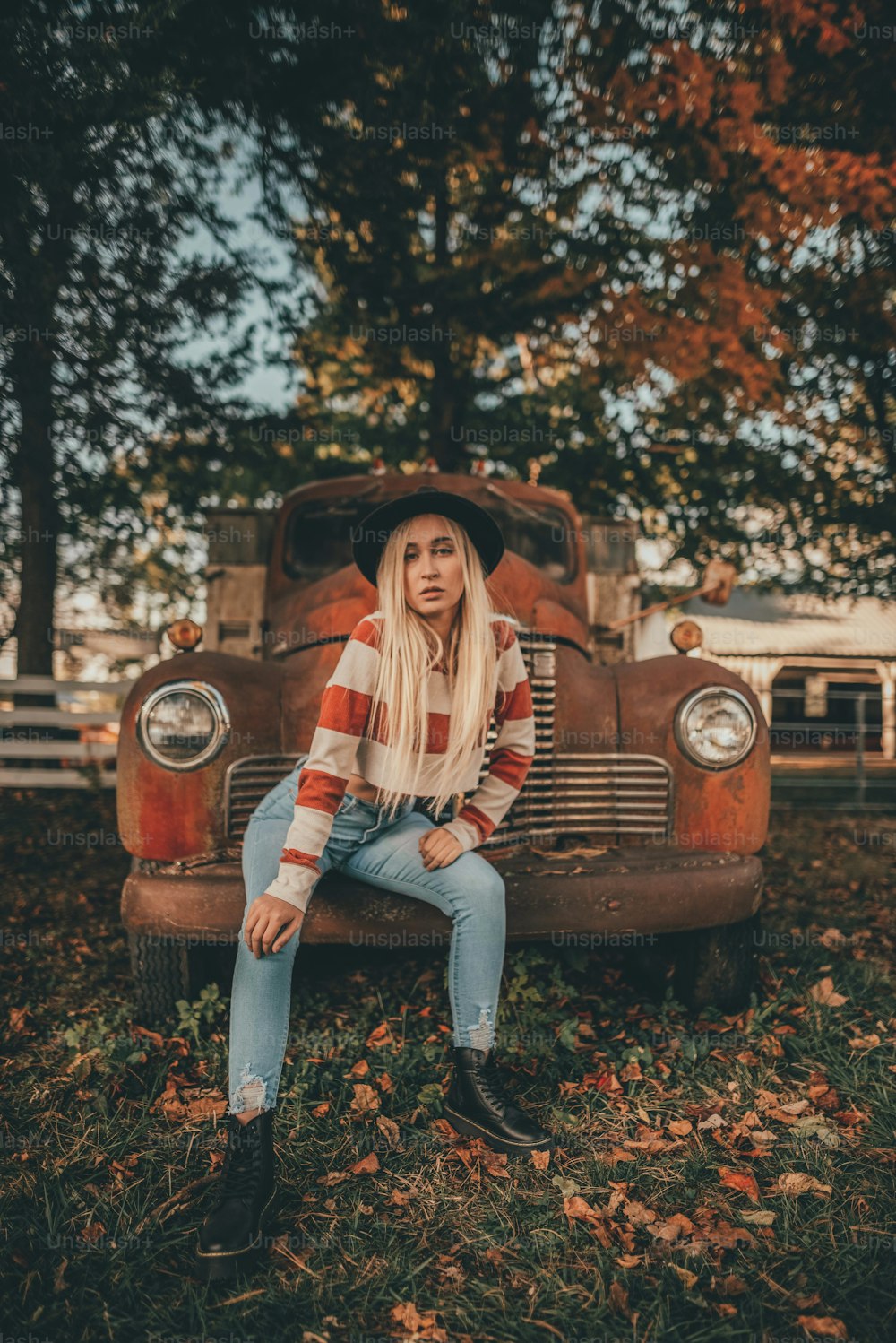 a woman sitting on the hood of an old truck