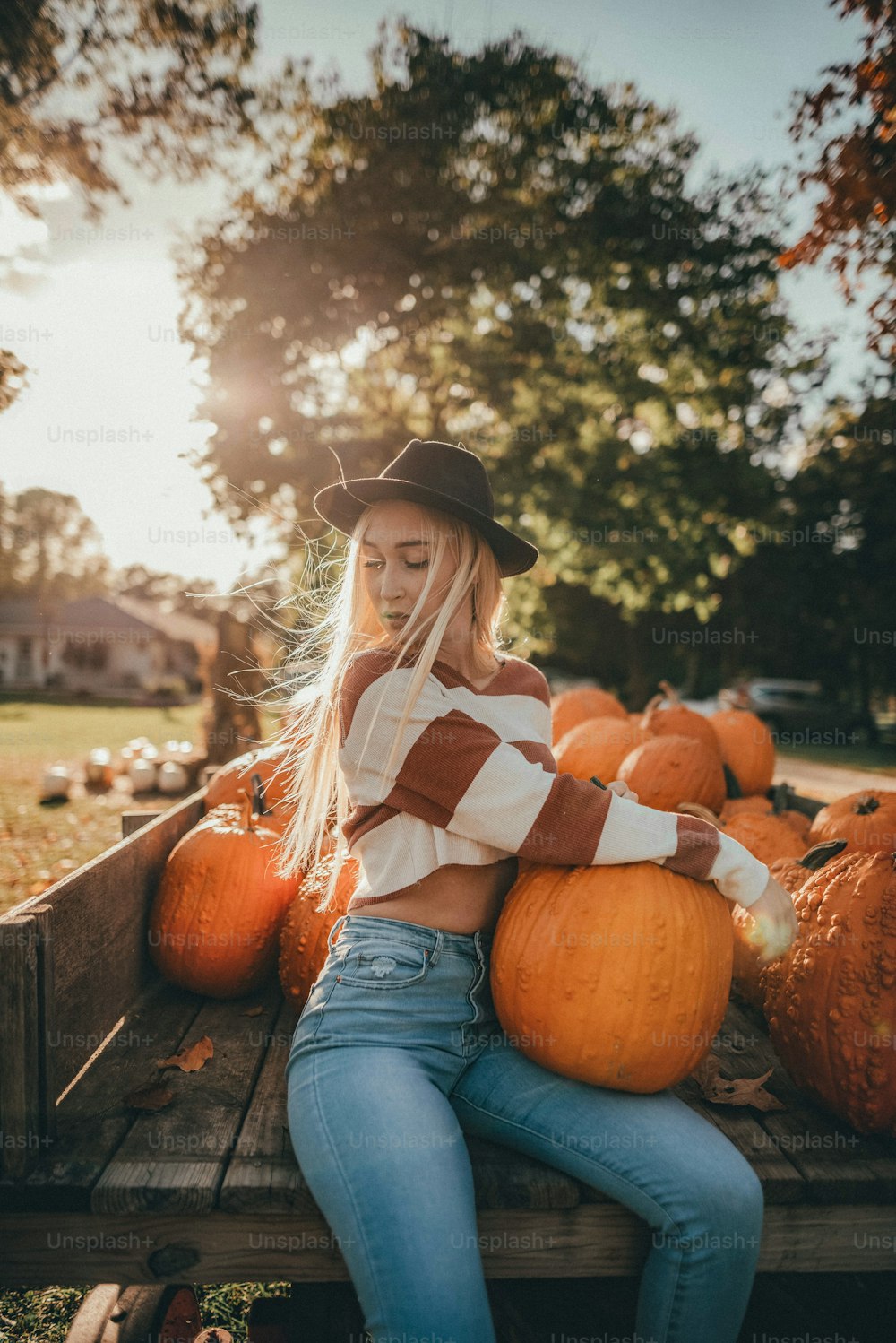 a woman sitting in a truck filled with pumpkins