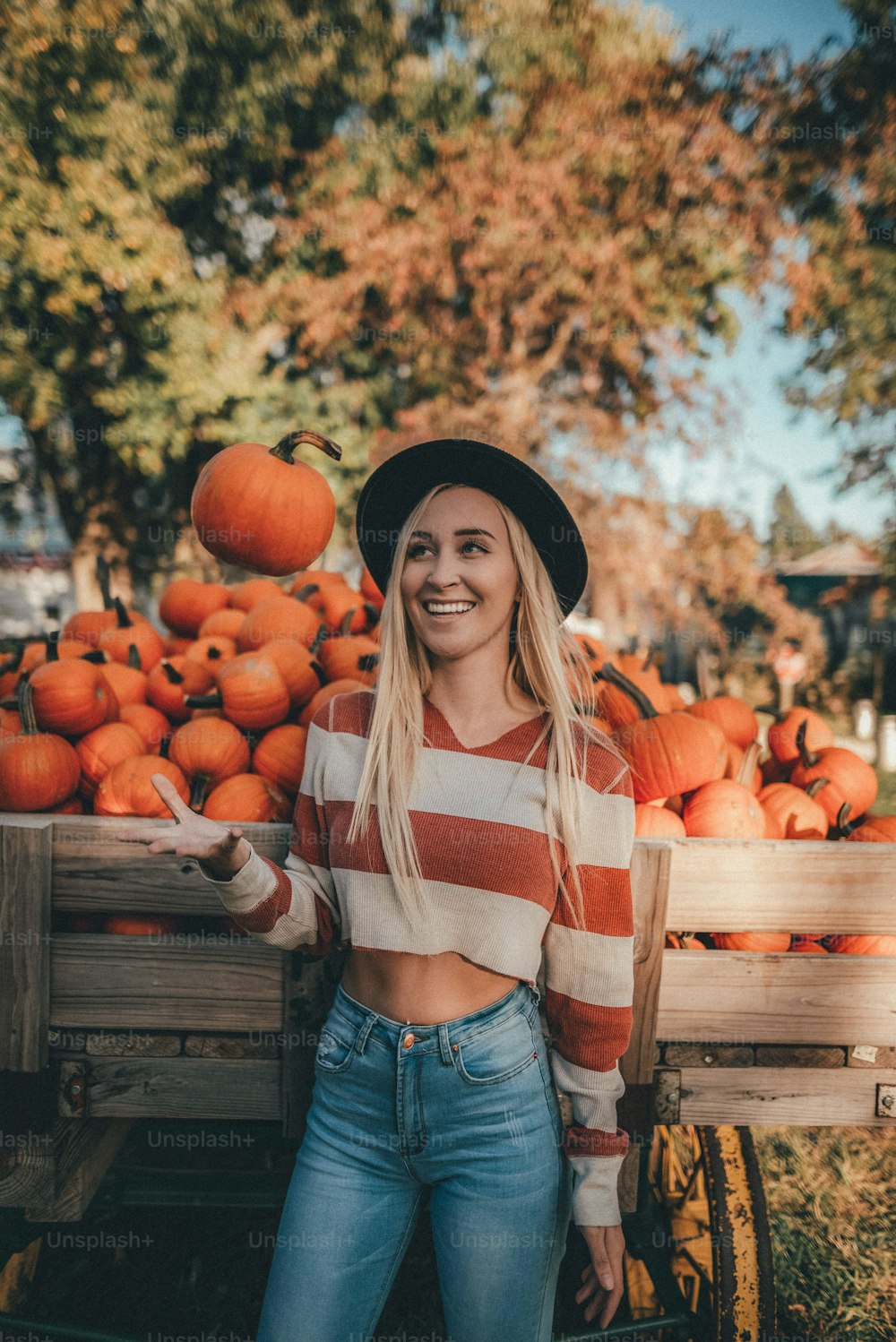 a woman standing in front of a cart full of oranges