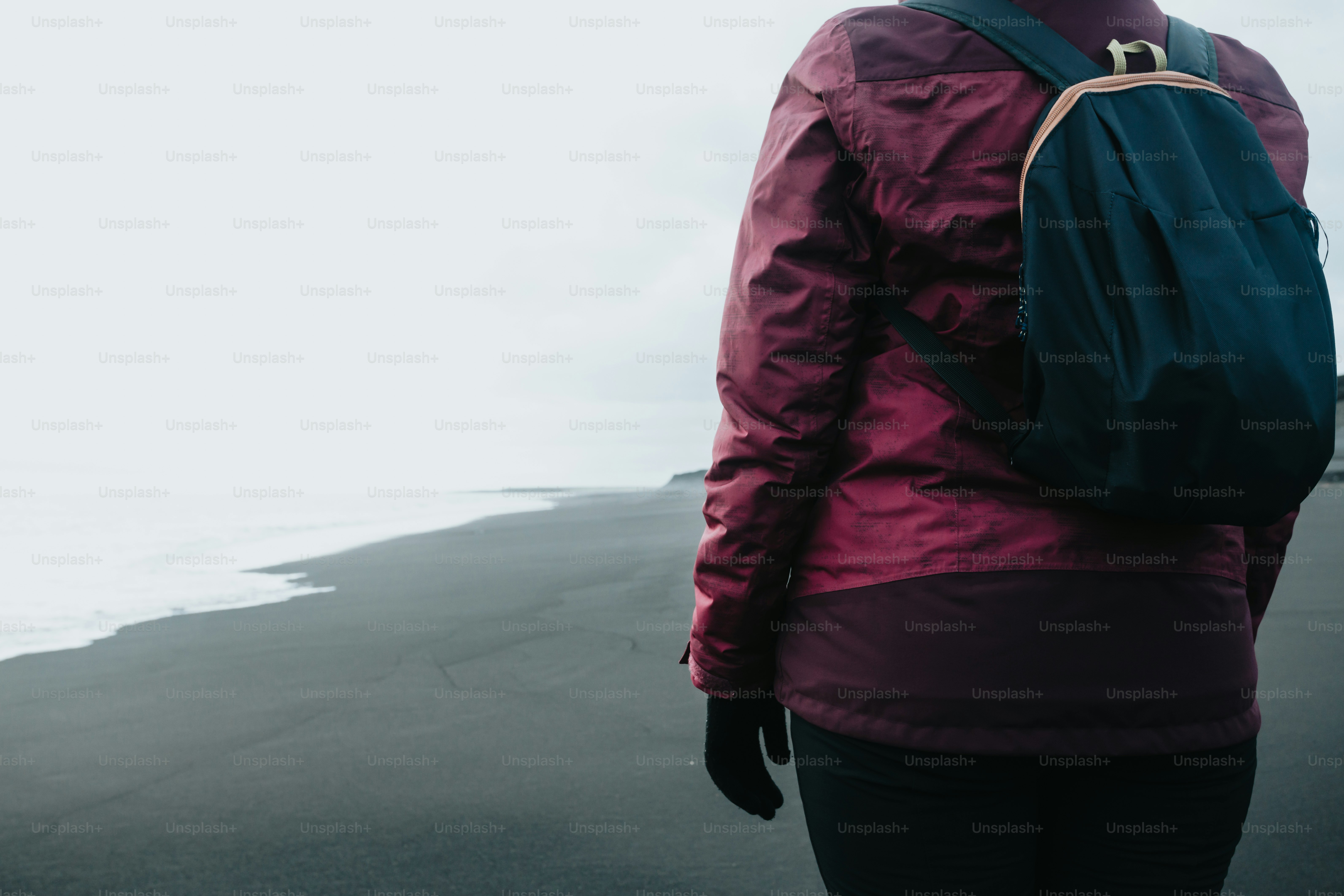 a person with a backpack walking on a beach