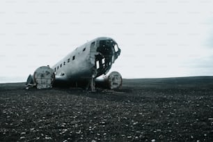 an old airplane sitting on top of a dirt field