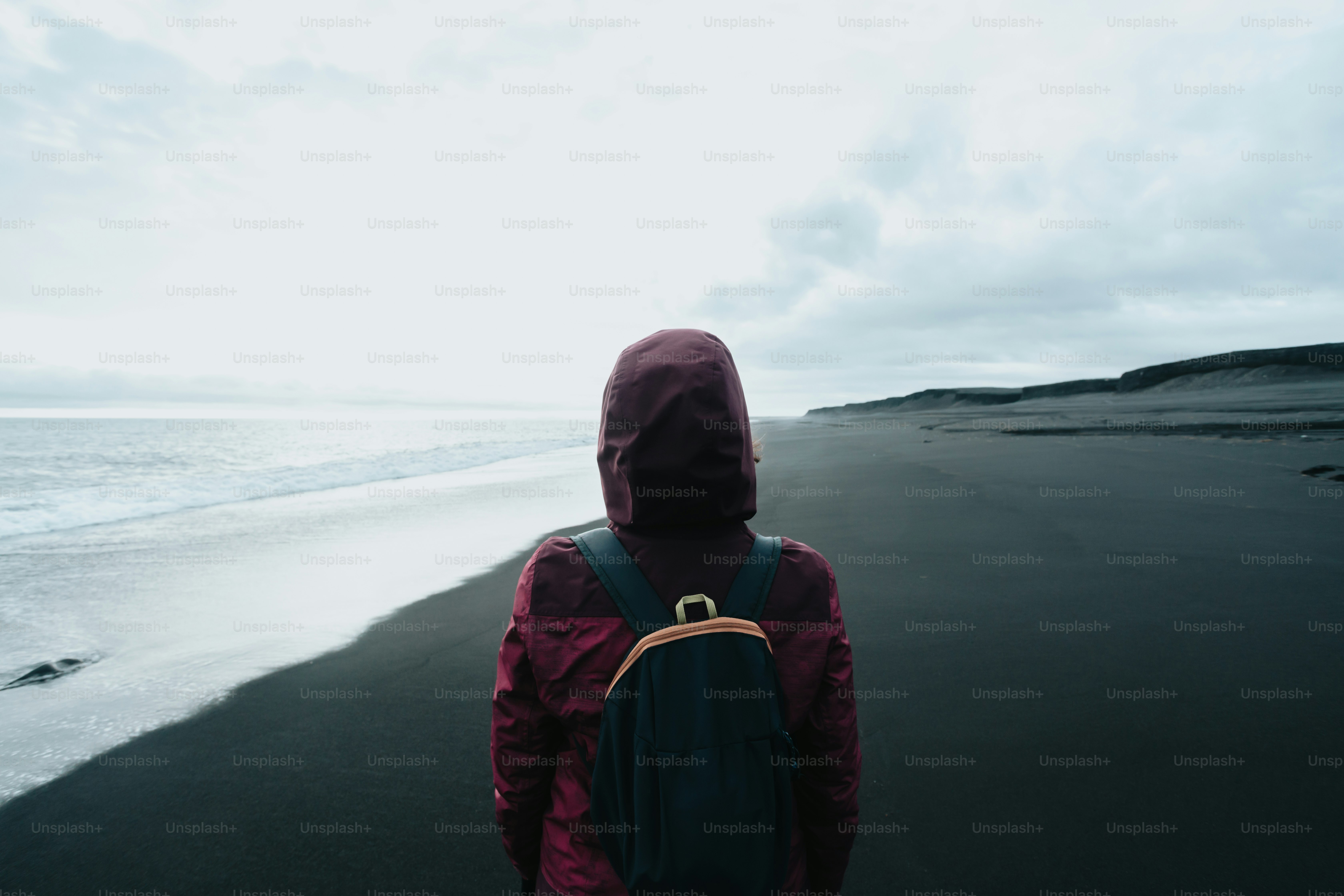 a person with a backpack walking on a beach