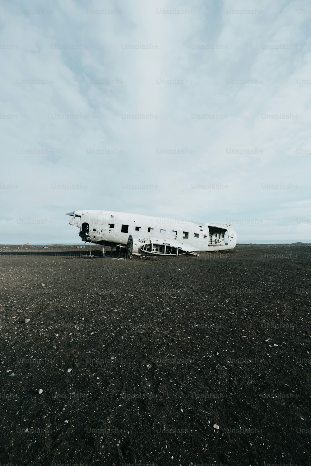 Un grande aeroplano bianco seduto in cima a un campo sporco