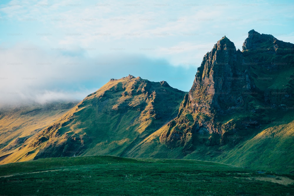 a very tall mountain with some clouds in the sky