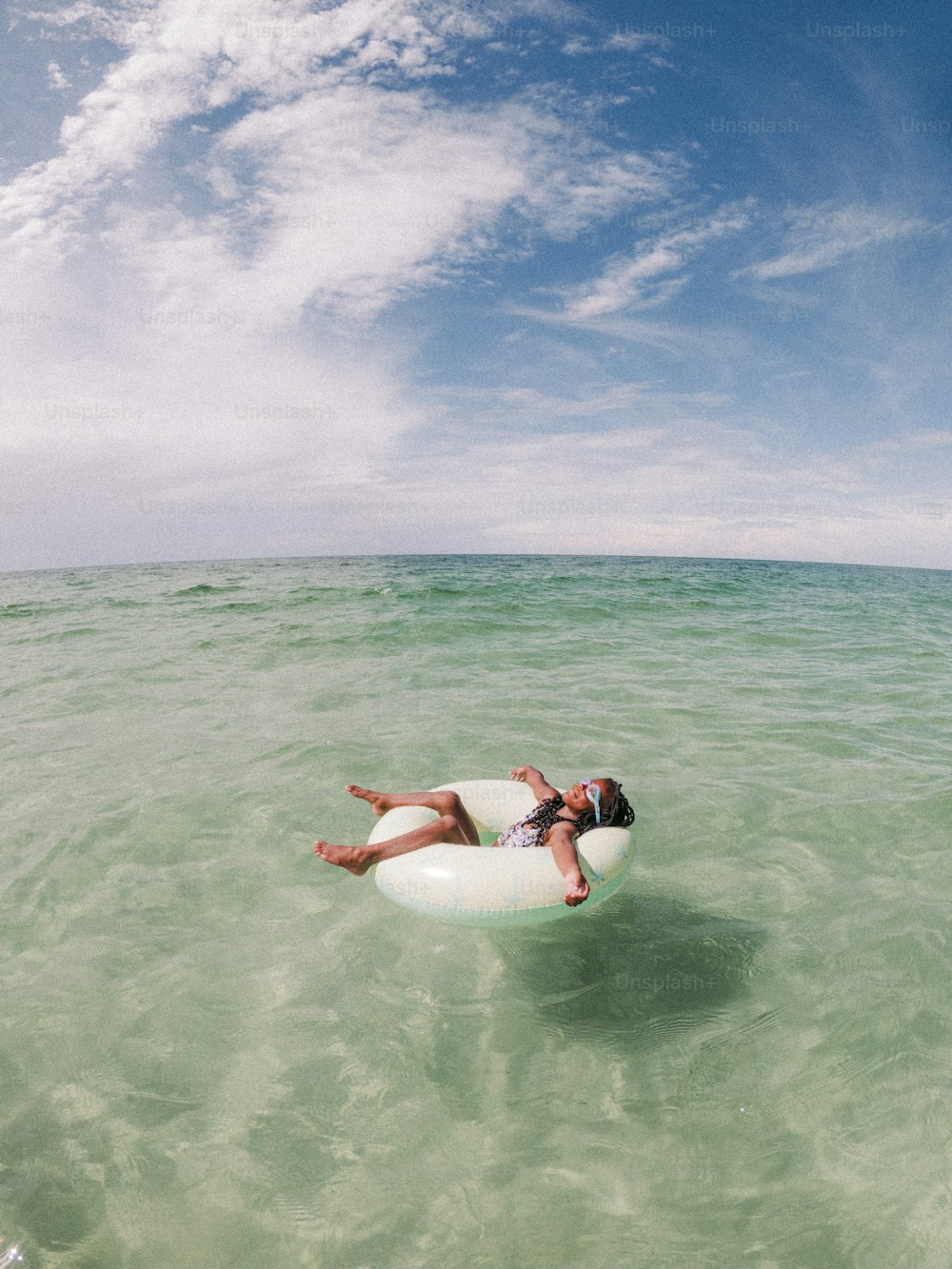 a person laying on a raft in the ocean