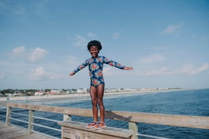 a young girl standing on a wooden pier