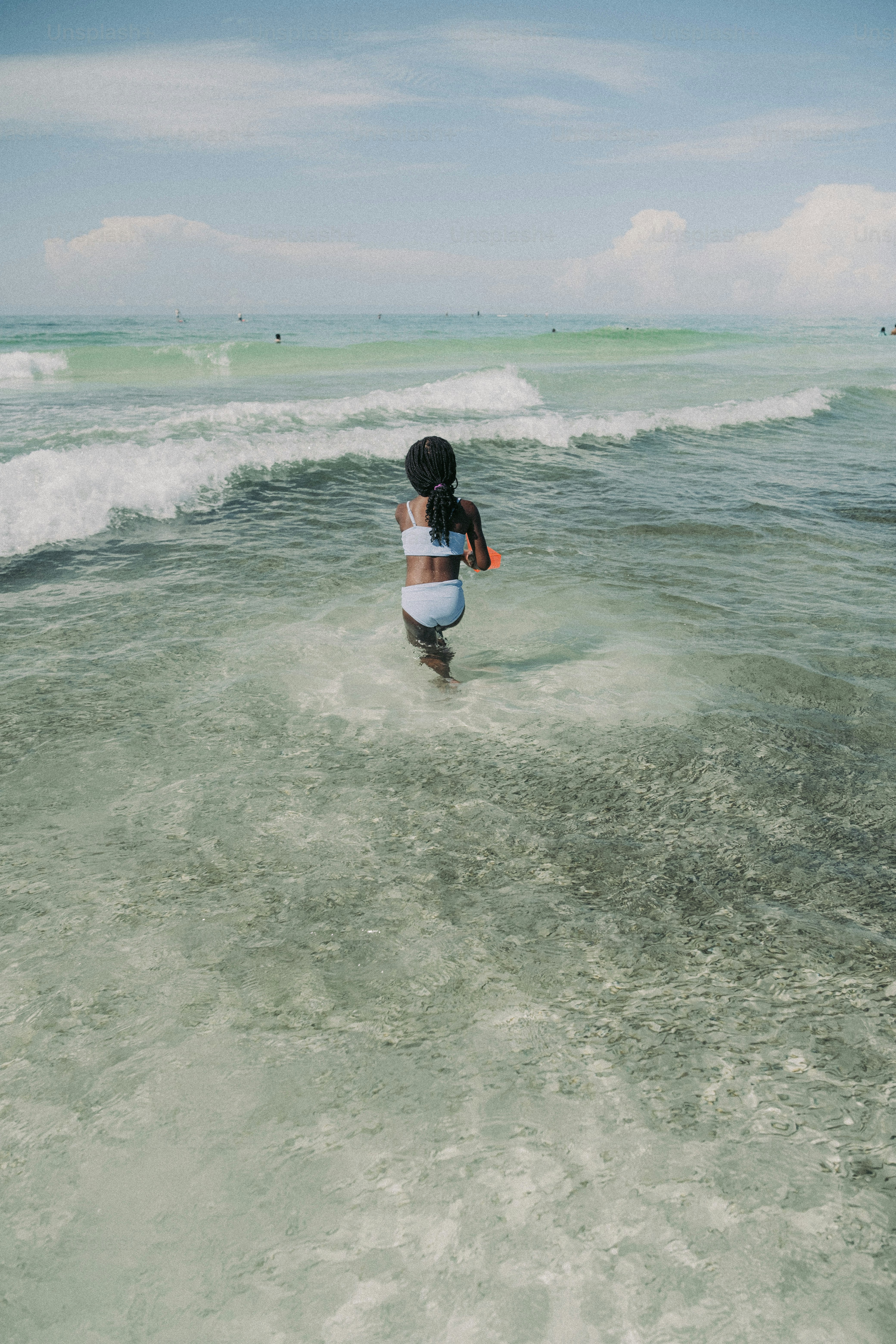 a little girl is running in the water