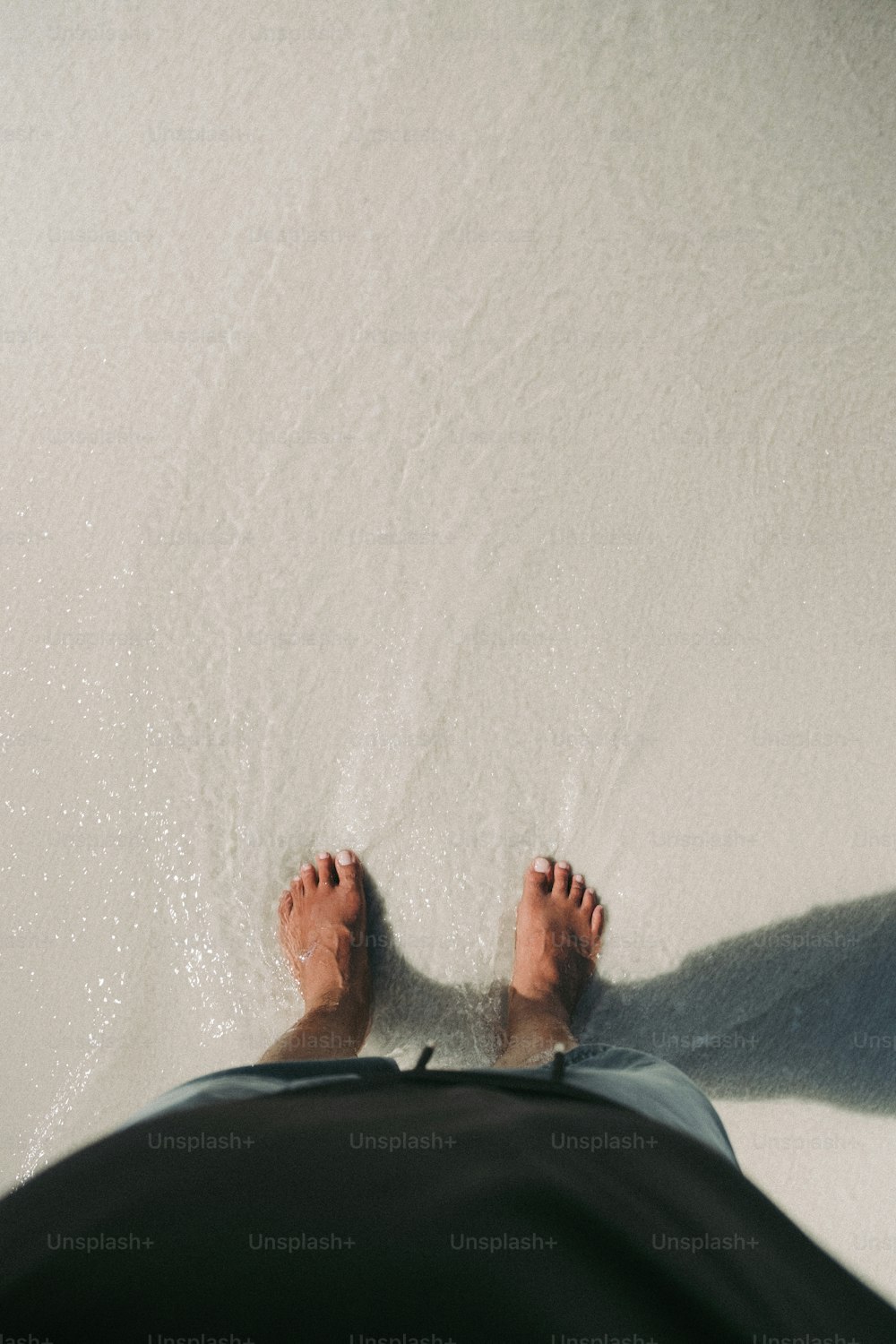 a person standing in the snow with their feet up