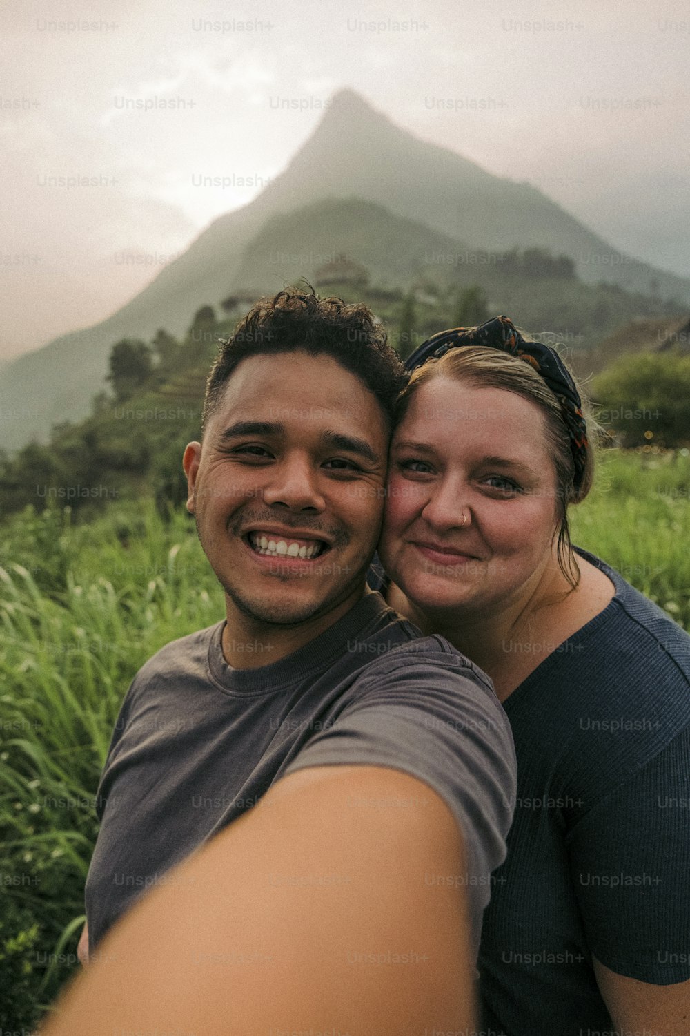 Un hombre y una mujer tomándose una selfie frente a una montaña