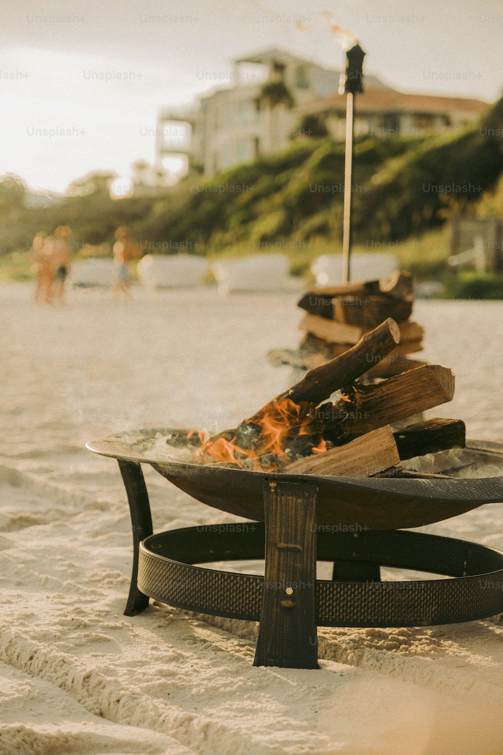 uma fogueira sentada em cima de uma praia de areia