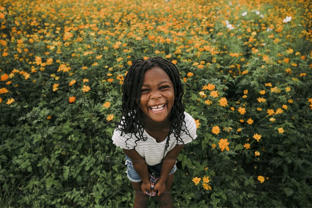 a little girl standing in a field of flowers