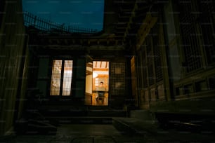 une porte ouverte menant à un bâtiment la nuit