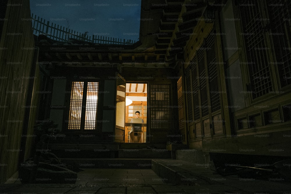 une porte ouverte menant à un bâtiment la nuit
