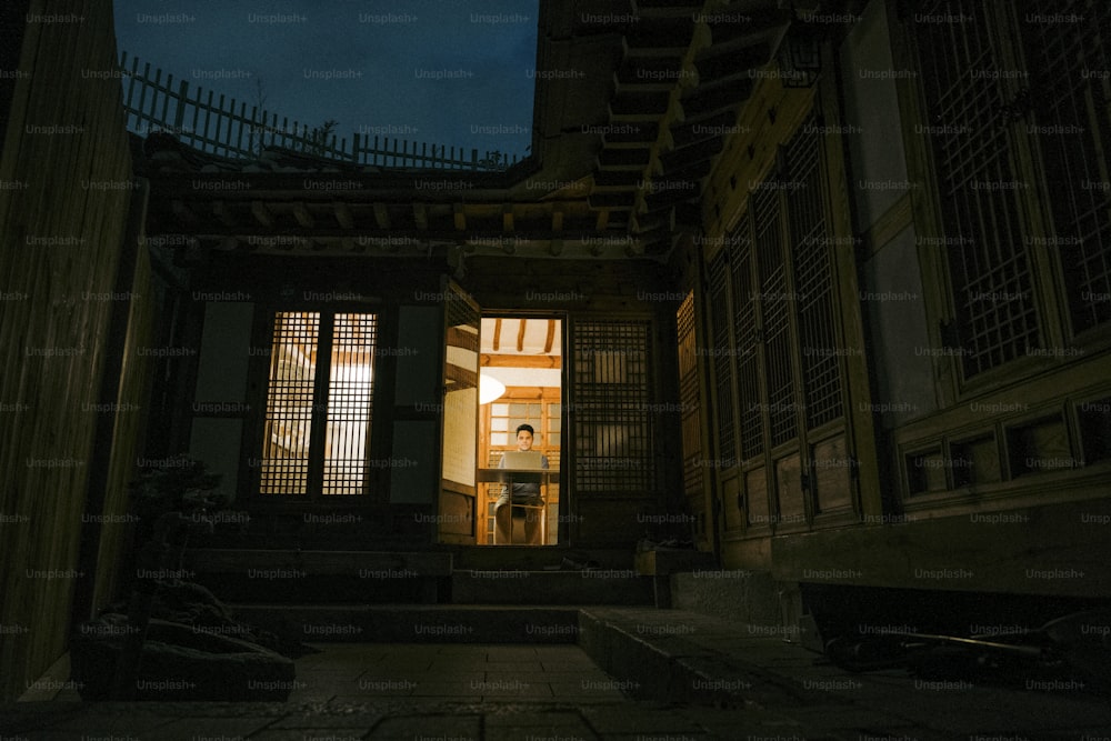 uma porta aberta que leva a um edifício à noite