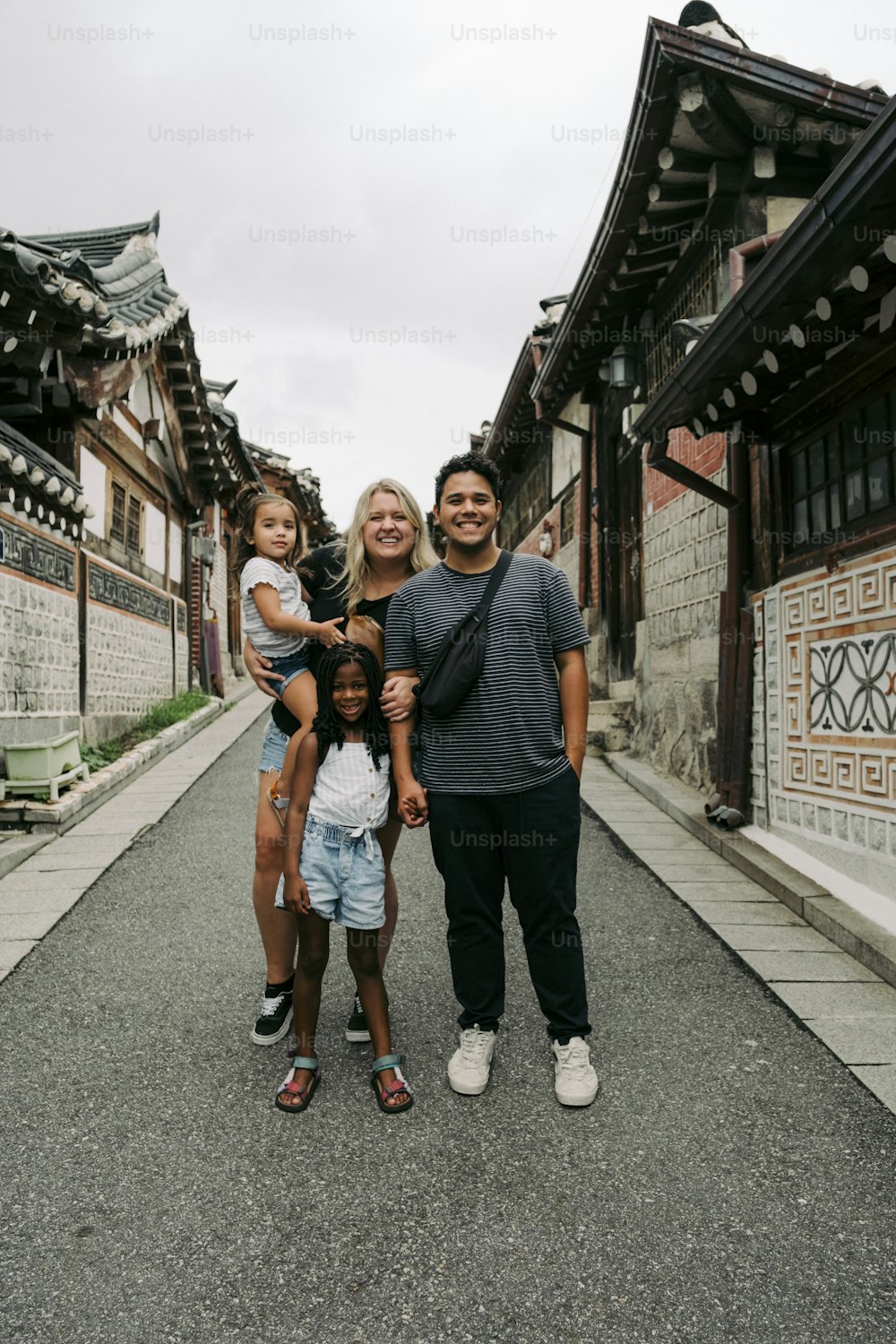 a man, woman, and two children are standing in the middle of a street