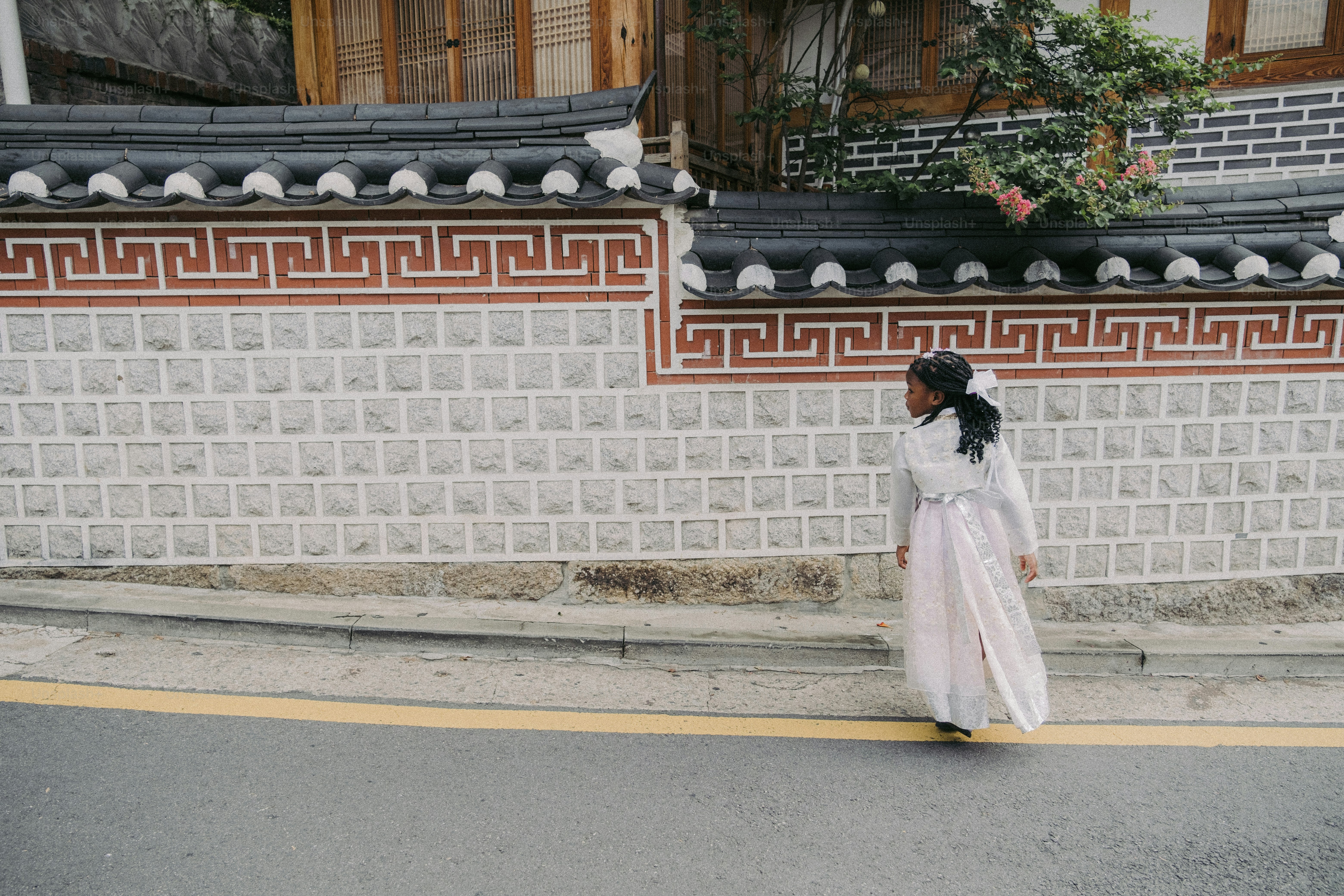 Uma mulher com um vestido branco está andando pela rua
