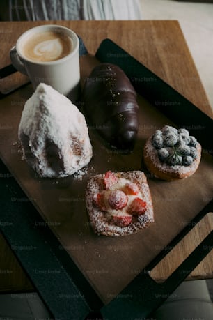 a wooden tray topped with pastries and a cup of coffee