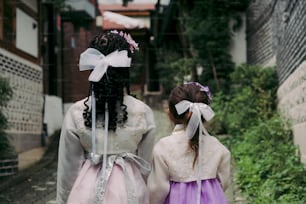two young girls walking down a street together