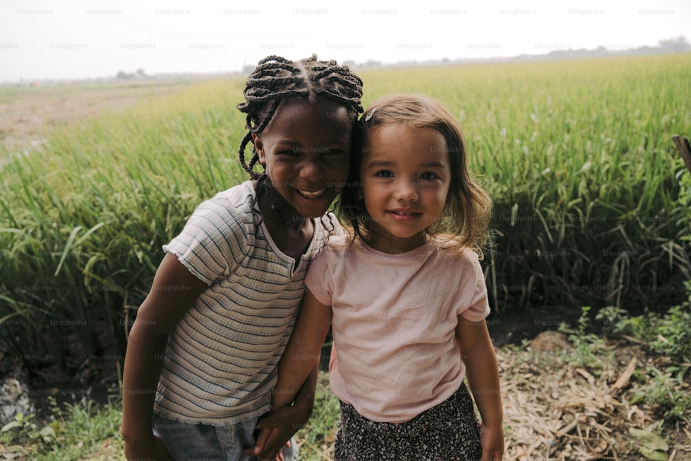 duas meninas em pé uma ao lado da outra em um campo