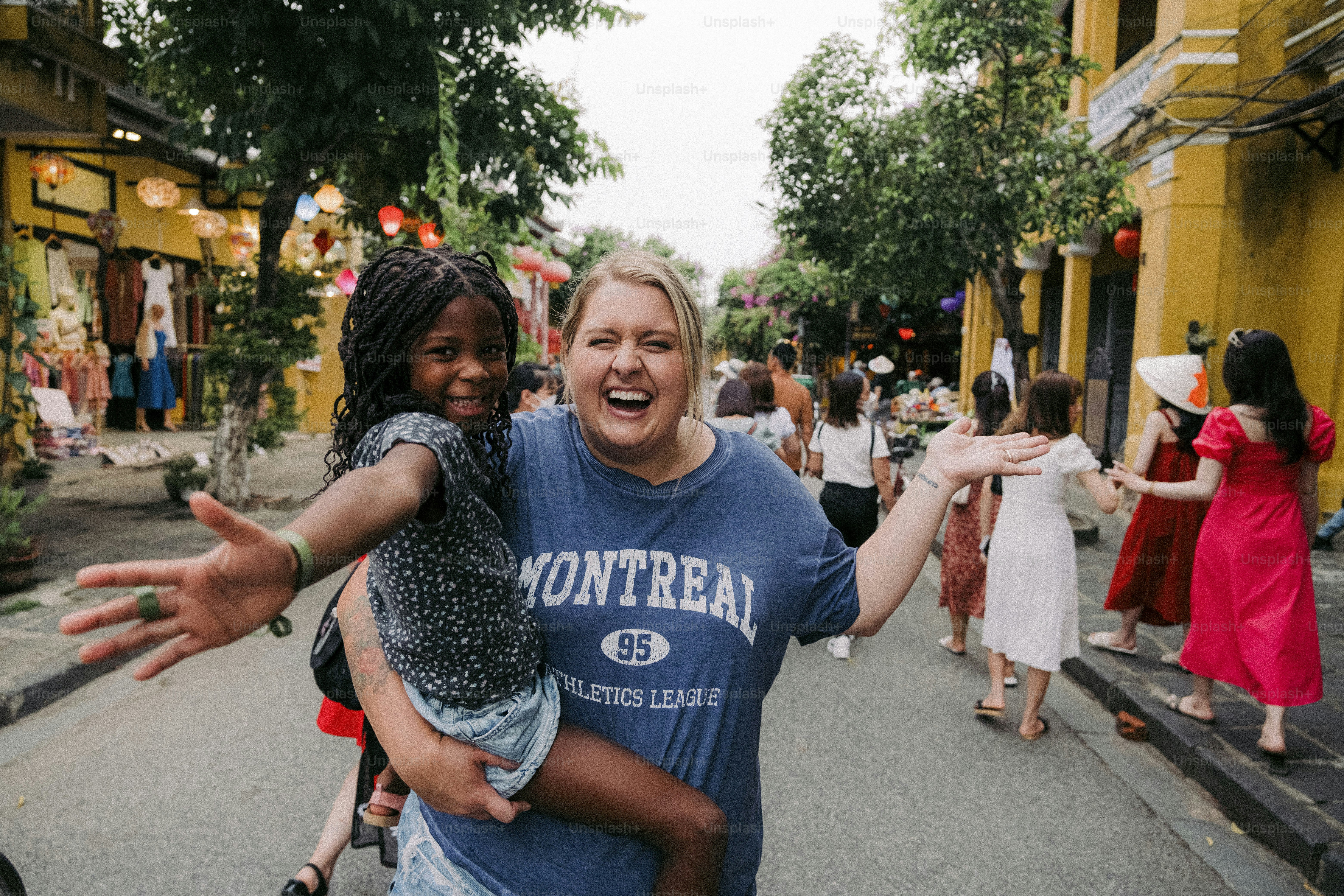Une femme tenant un enfant au milieu d’une rue