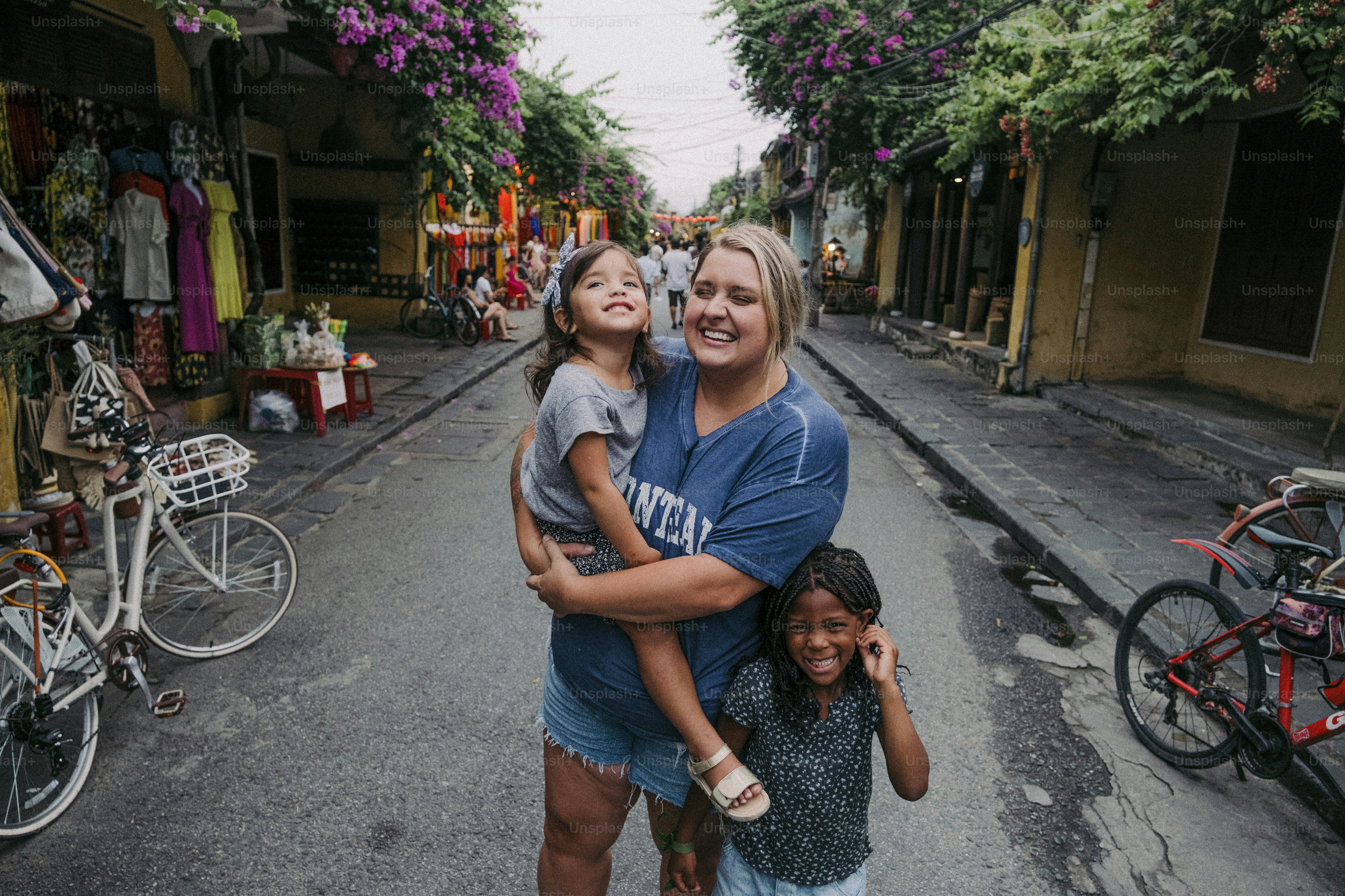 a woman and two children standing in the middle of a street