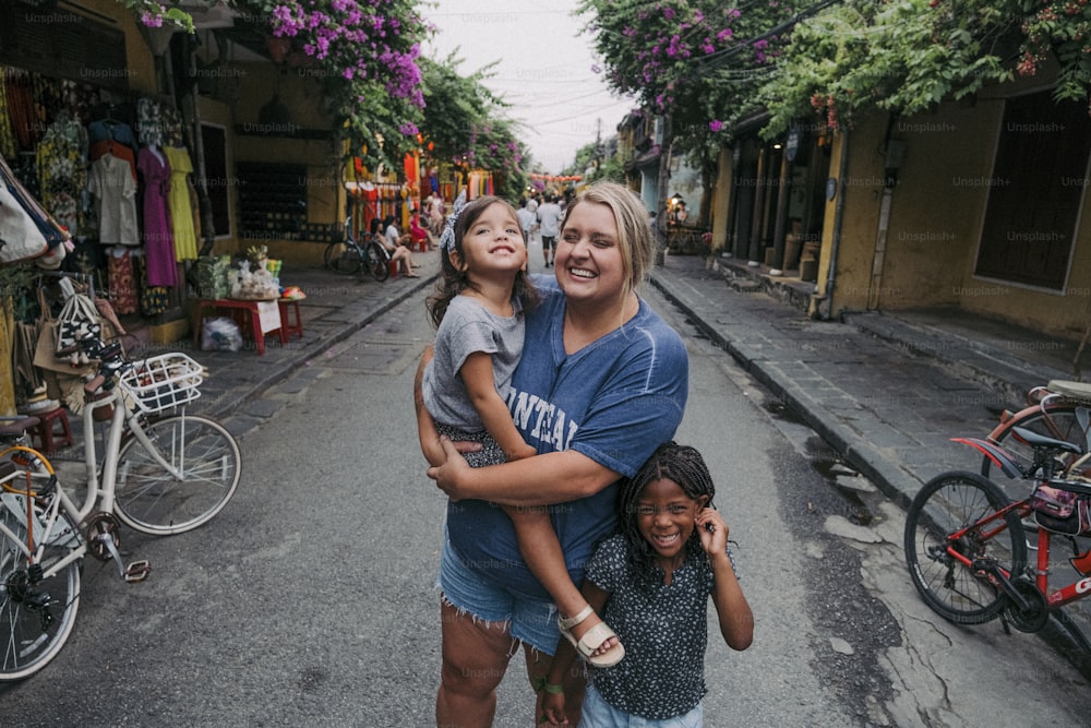 通りの真ん中に立つ女性と2人の子供